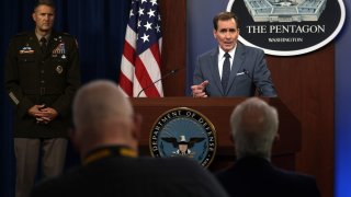 U.S. Department of Defense Press Secretary John Kirby (R) speaks as Army Major General William Taylor (L) listens during a news briefing