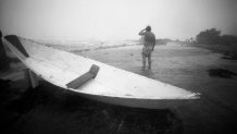 A person looks out over Great Harbor in Woods Hole, Mass., on Aug. 19, 1991, during Hurricane Bob.