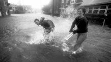 Two people play in a flooded Water Street in downtown Woods Hole, Mass., during Hurricane Bob on Aug. 19, 1991.