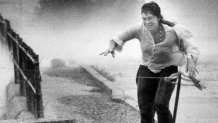 A woman runs for cover during Hurricane Bob along the waterfront at Woods Hole in Falmouth, Mass., on Aug. 19, 1991.