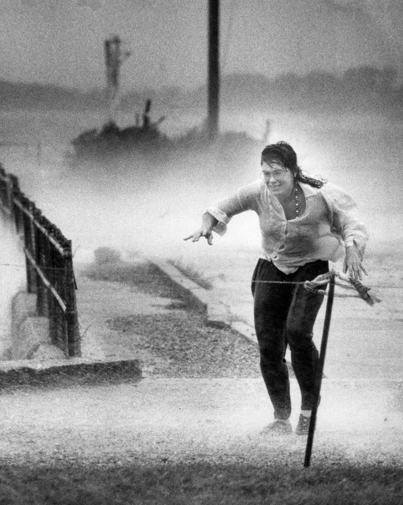 A woman runs for cover during Hurricane Bob along the waterfront at Woods Hole in Falmouth, Mass., on Aug. 19, 1991.