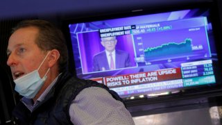 A trader works on the trading floor as a screen displays a statement by Federal Reserve Chair Jerome Powell following the U.S. Federal Reserve’s announcement at the New York Stock Exchange (NYSE), September 22, 2021.