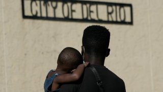 A Haitian migrant carries a boy