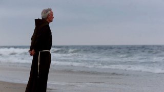 In this July 17, 2000, file photo, the Rev. Mychal Judge, the Fire Department of New York's chaplain with the New York City Fire Department, stands at the shore before a service to remember the 230 people who died on July 17