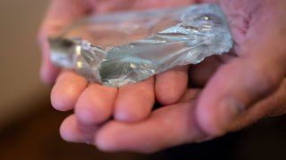 Retired NYPD Officer Ken Winkler, holds a broken piece of glass that he kept from the fallen World Trade Center skyscrapers