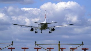A plane lands on the southern runway at London Heathrow Airport. US and EU travellers who are fully vaccinated against coronavirus will be allowed to enter England and Scotland without the need to quarantine from Monday.