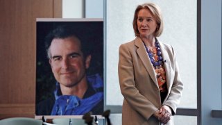 FILE - In this Feb. 21, 2018, file photo, Seattle Mayor Jenny Durkan, former U.S. Attorney for the Western District of Washington, stands near a photo of slain Assistant United States Attorney Thomas Wales in Seattle. Rewards totaling $2.5 million are now being offered for information that helps solve the killing of Wales in Seattle 20 years ago.