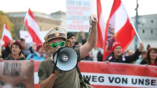 VIENNA, AUSTRIA – OCTOBER 26: People, holding placards and banners, gather to protest against COVID-19 measures, vaccination and government following the increasing number of cases in recent days.