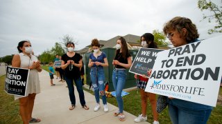 Anti-abortion demonstrators pray and protest outside of a Whole Women's Health of North Texas