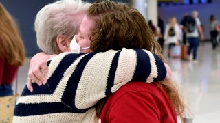 Jocelyn Ragusin hugs her mother, who arrived at Denver International Airport from Rapid City, South Dakota, on Tuesday, Nov. 23, 2021.