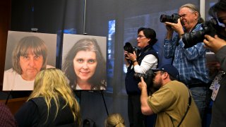 Members of the media photograph police photos of fifty-seven-year-old David Allen Turpin, left, and 49-year-old Louise Anna Turpin, center