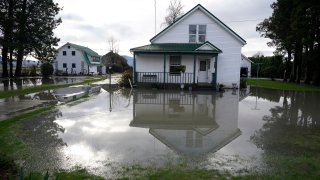 A house sitting barely above floodwaters is shown near Everson, Wash., Monday, Nov. 29, 2021. Localized flooding was expected Monday in Washington state from another in a series of rainstorms, but conditions do not appear to be as severe as when extreme weather hit the region earlier in November.