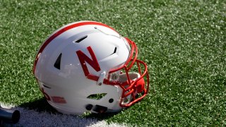 A Nebraska Cornhuskers helmet rests on the field