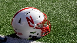 A Nebraska Cornhuskers helmet rests on the field