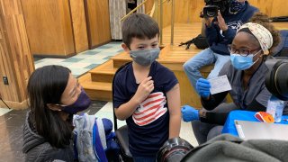 Boston Mayor Michelle Wu with her son Blaise during his vaccination against COVID in Boston on Saturday, Nov. 20, 2021.