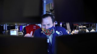 A trader in a face mask works on the trading floor at the New York Stock Exchange (NYSE) as the Omicron coronavirus variant continues to spread in Manhattan, New York City, U.S., December 20, 2021.