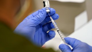 FILE - A healthcare worker fills a syringe with the Pfizer COVID-19 vaccine at Jackson Memorial Hospital, Oct. 5, 2021, in Miami. Nearly 8,500 active duty members of the Air Force and Space Force have missed the deadline for getting COVID-19 vaccinations, including 800 who flatly refused and nearly 5,000 with pending requests for a religious exemption, the Air Force said Wednesday, Nov. 3.