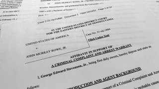 The affidavit, criminal complaint and arrest warrant for John Murray Rowe Jr., is photographed on Dec. 16, 2021. The Justice Department says the engineer who worked for decades as a federal defense contractor has been arrested on charges of trying to pass classified information to someone he thought was a Russian agents but who was actually an undercover FBI employee.