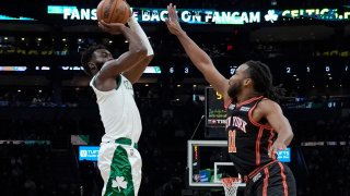 Boston Celtics guard Jaylen Brown (7) shoots a 3-point shot over New York Knicks forward Wayne Selden (11) during the first half of an NBA basketball game, Saturday, Dec. 18, 2021, in Boston.