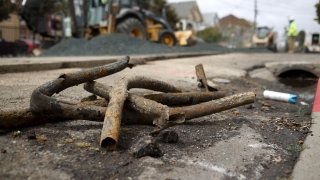 Old rusty utility pipes sit on the ground