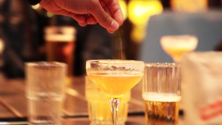 A file photo showing a person appearing to sprinkle drugs into a drink at a bar