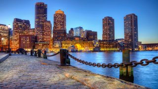 Boston harborwalk slightly processed using HDR technique. Photo taken along the waterfront at night in the South Boston southie neighborhood at night. The Boston cityscape is a mixture of old and new buildings. Boston is the capital and largest city in Masssachusetts. Boston is the largest city in New England.
