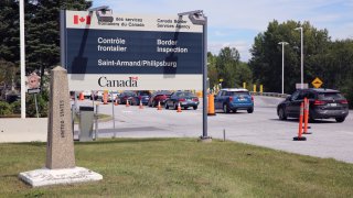 Cars pass a monument marking the border between the United States and Canada on Wednesday, Sept. 1, 2021, at Highgate Springs, Vt.
