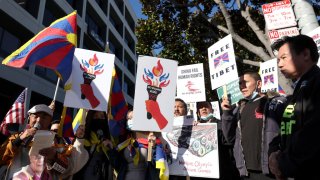 Protesters hold signs during a demonstration outside of the NBC Sports office