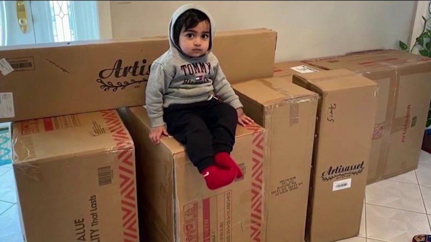 Toddler sitting on top of boxes of furniture he ordered online