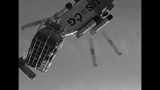 A Coast Guard helicopter lifts a stranded hunter from a marsh on Cape Cod on Saturday, Jan. 15, 2022.