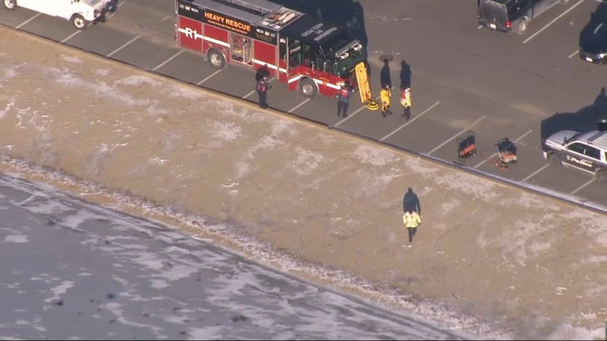 First responders recovering a body from Learned Pond in Framingham, Massachusetts, on Tuesday, Jan. 11, 2022.