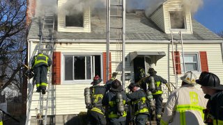 firefighter climb ladders to fight home blaze