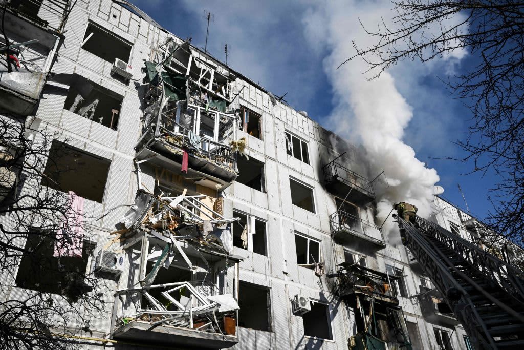 Firefighters work on a building caught on fire after the eastern Ukraine town of Chuguiv was bombed,, Feb. 24, 2022, as Russian armed forces are trying to invade Ukraine from several directions.