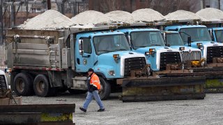 A City of Chicago Department of Streets and Sanitation employee walks from a loaded salt truck to an empty salt truck to be loaded in anticipation of a winter storm Tuesday, Feb. 1, 2022, in Chicago. A major winter storm is expected to affect a huge swath of the United States beginning Tuesday, with heavy snow starting in the Rockies and freezing rain as far south as Texas before it drops snow and ice on the Midwest.