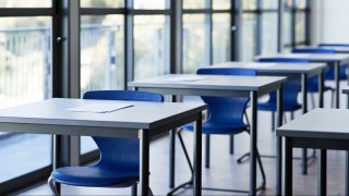 Papers on desks by window in classroom