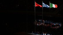 The flags of China, Greece and Italy sway in the wind during the closing ceremony of the 2022 Winter Olympic Games, Feb. 20, 2022.