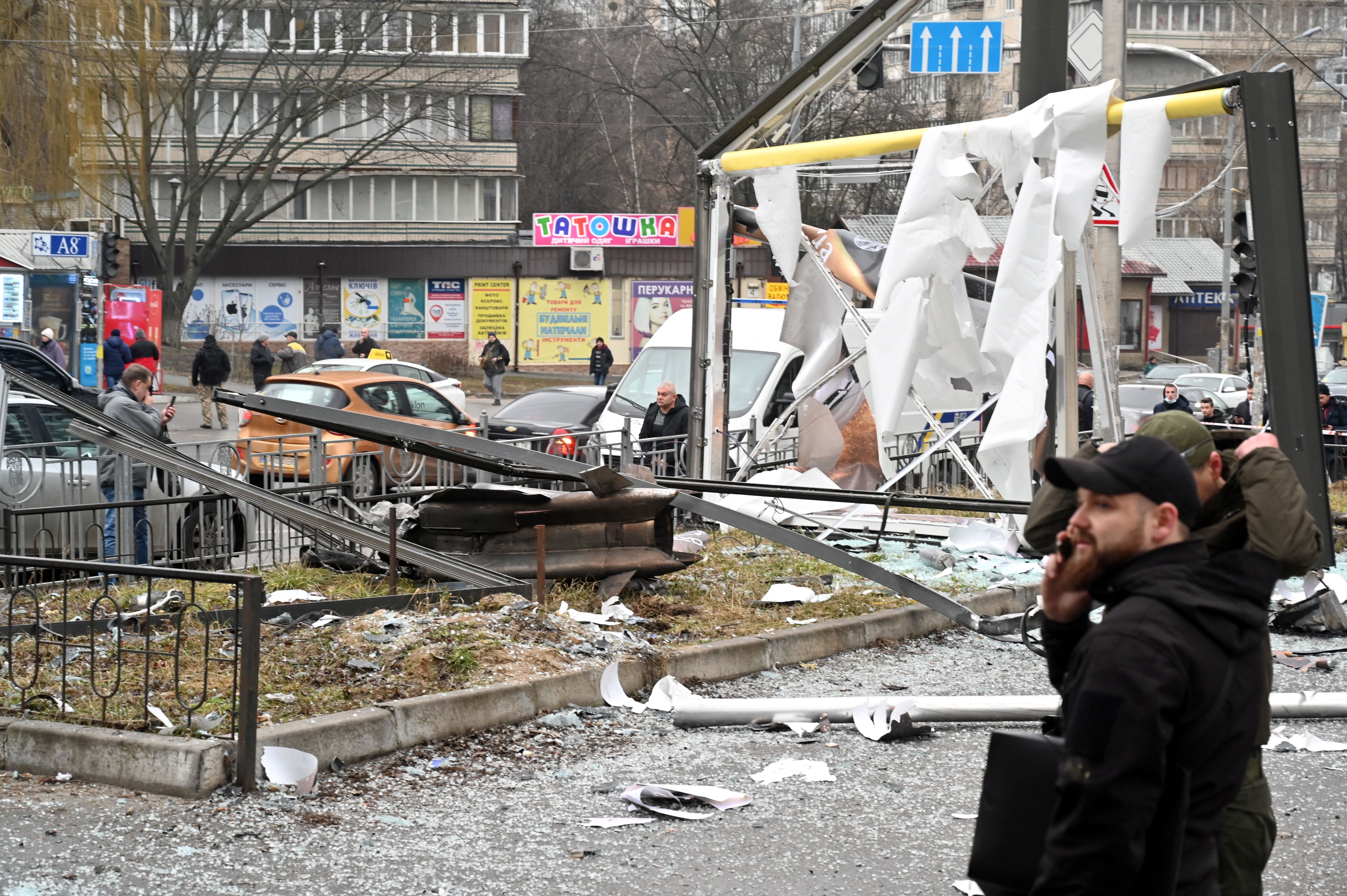 Police and security personnel inspect gather by the remains of a shell landed in a street in Kyiv on Feb. 24, 2022.  Russian President Vladimir Putin announced a military operation in Ukraine on Thursday with explosions heard soon after across the country and its foreign minister warning a “full-scale invasion” was underway.