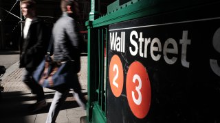 People walk along Wall Street near the New York Stock Exchange on March 08, 2022 in New York City.