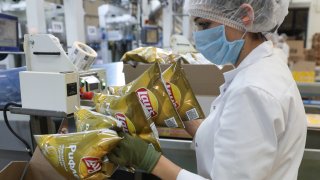 A worker packs finished products into boxes at a PepsiCo plant in Rostov-on-Don Region, Russia, October 8, 2021.