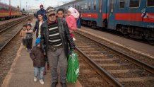 Refugees fleeing the war from neighboring Ukraine walk on a platform after disembarking from a train in Zahony, Hungary, Wednesday, March 2, 2022. At the train station in the Hungarian town of Zahony on Wednesday, more than 200 Ukrainians with disabilities — residents of two care homes in Ukraine's capital of Kyiv — disembarked into the cold wind of the train platform after an arduous escape from the violence gripping Ukraine.