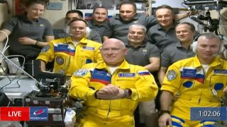 In this frame grab from video provided by Roscosmos, Russian cosmonauts Sergey Korsakov, Oleg Artemyev and Denis Matveyev are seen during a welcome ceremony after arriving at the International Space Station, Friday, March 18, 2022, the first new faces in space since the start of Russia’s war in Ukraine. The crew emerged from the Soyuz capsule wearing yellow flight suits with blue stripes, the colors of the Ukrainian flag.