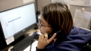 FILE - A volunteer at the Samaritans Call Center takes a call at the office in Boston on Feb. 28, 2020. The volunteers answer phone calls from the National Suicide Prevention Lifeline.