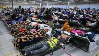 People who fled the war in Ukraine rest inside a temporary refugee shelter that was an abandoned TESCO supermarket after being transported from the Polish Ukrainian border on March 08, 2022 in Przemysl, Poland.