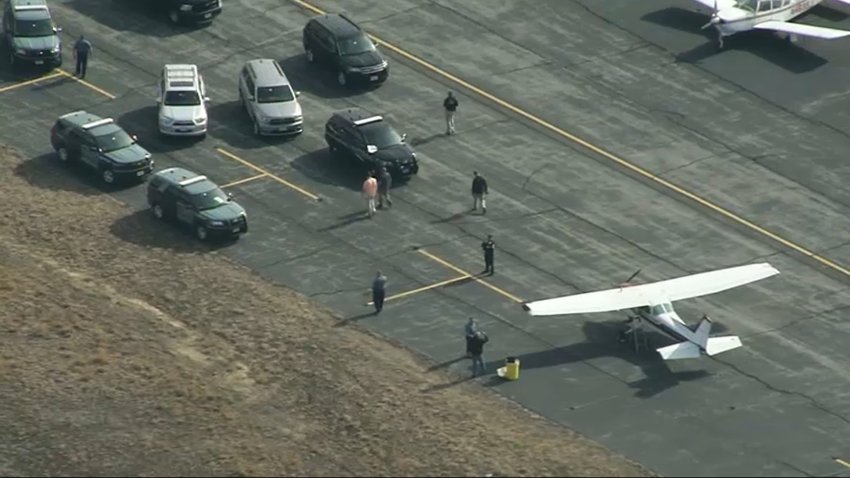 Law enforcement surrounding a small plane at the Gardner Municipal Airport Monday.