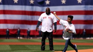 Former Red Sox player Mo Vaughn and his son Lee throw out the ceremonial first pitch on Opening Day at Fenway Park on April 15, 2022 in Boston, Massachusetts. All players are wearing the number 42 in honor of Jackie Robinson Day.