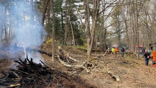 Ipswich Firefighters work at 10 Mill Road, where a permitted brush pile fire grew out of control on Monday morning.