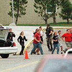 Students run from Columbine High School run under cover from police