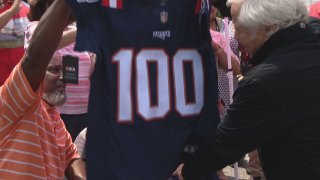 Sgt. Victor Butler receives a jersey with the No. 100 from the New England Patriots for his 100th birthday on Saturday, May 21, 2022.