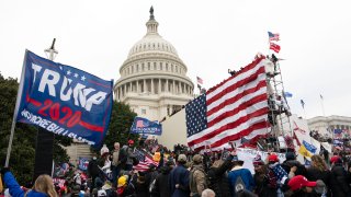 FILE - Rioters stand outside the U.S. Capitol in Washington, on Jan. 6