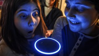 A family poses with "Alexa", an artificial intelligence device